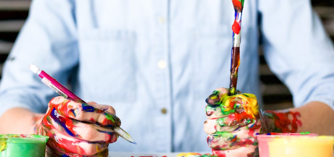 Man with hands covered in paint.
